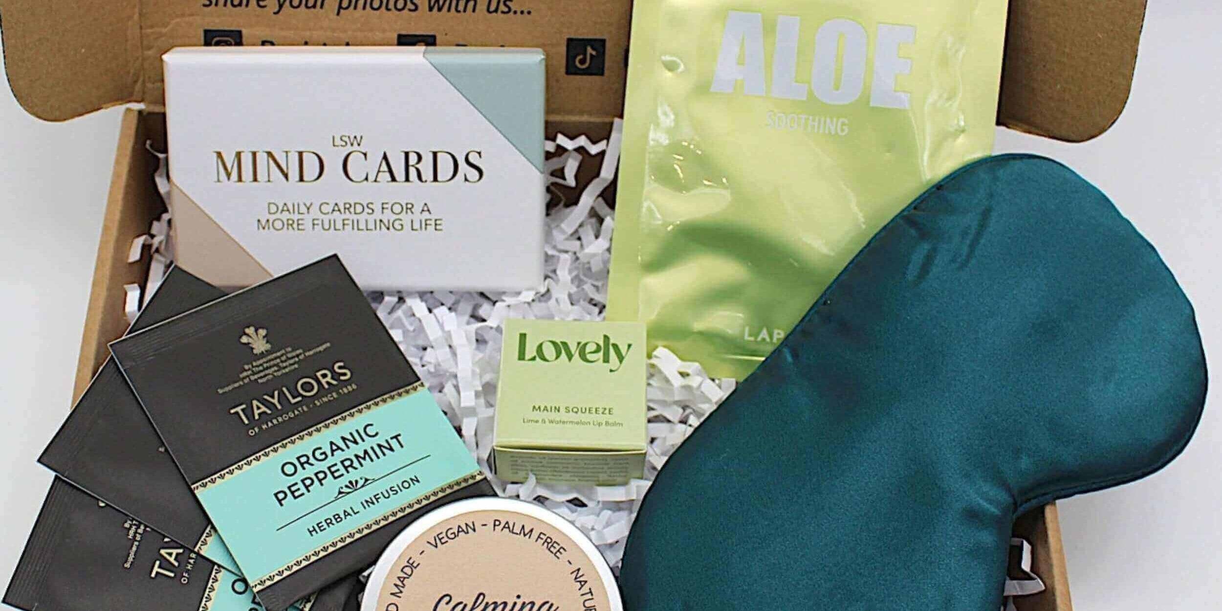 Gifts for mental health wellness in a self-care box with bath salts, tea, and relaxation items.