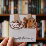 Magnetic book marks held up in front of books. 