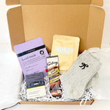 Christmas pamper gift box with honey face mask, hand mask, lavender bath bar, grey bow socks and Galaxy hot chocolate