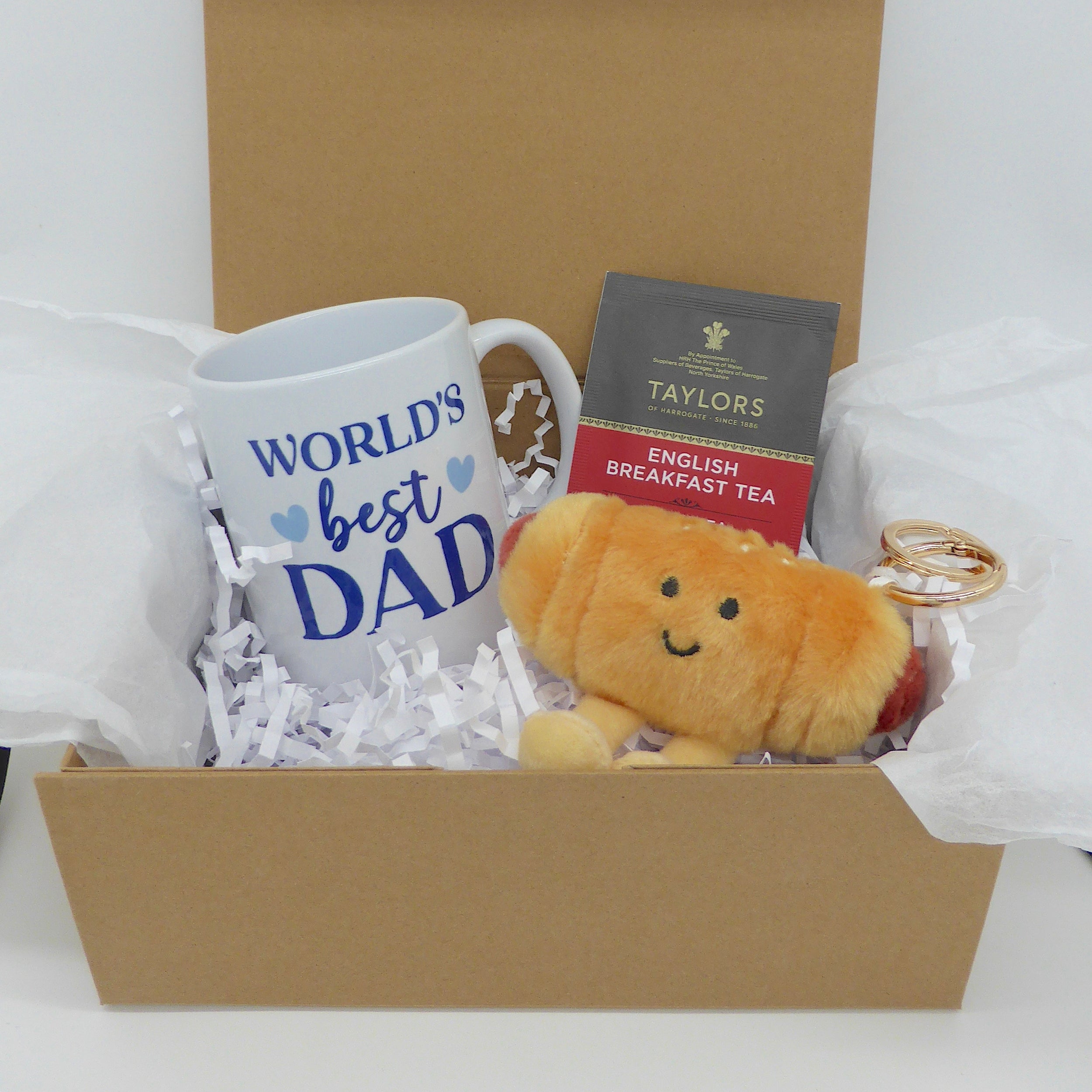 Gift box with 'World's Best Dad' mug, tea, and plush sausage roll keyring in magnetic closure box. 