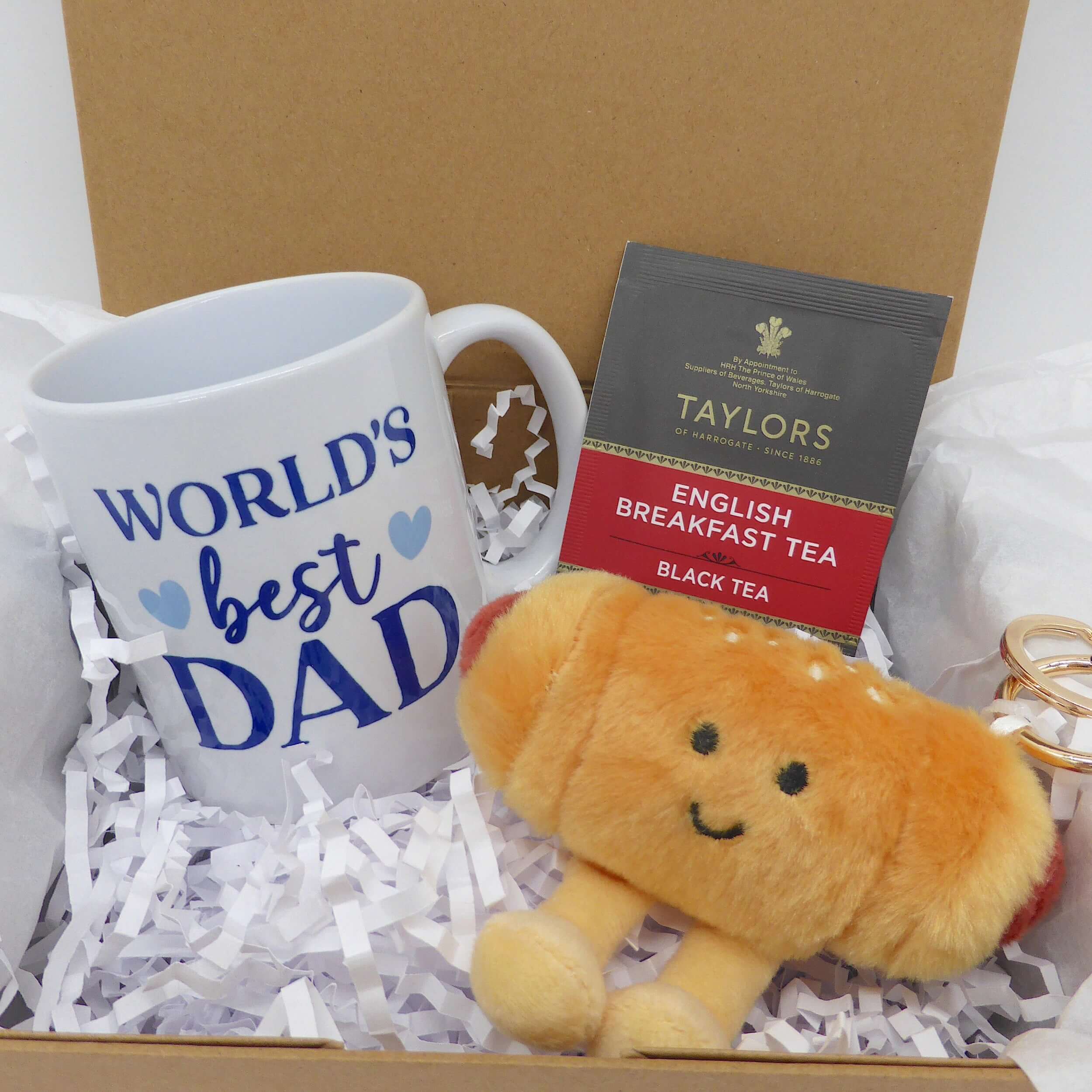 cozy gift set for dad featuring a coffee mug, tea, and plush croissant in a gift box.