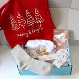 Festive merry and bright ift box, blue gift box with white satin sleep mask, pearl sheet mask, dotted star tea light holder, 3 aromatherapy soy wax tea llights, cashmere grey socks, sensual bath bomb, and Lindt reindeer. .    