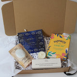 Happiness gift box is presented in brown gift box, with sensory retreat self heating mask, aromatherapy bath salts, happiness for every day quote book. 3 aromatherapy tea lights   