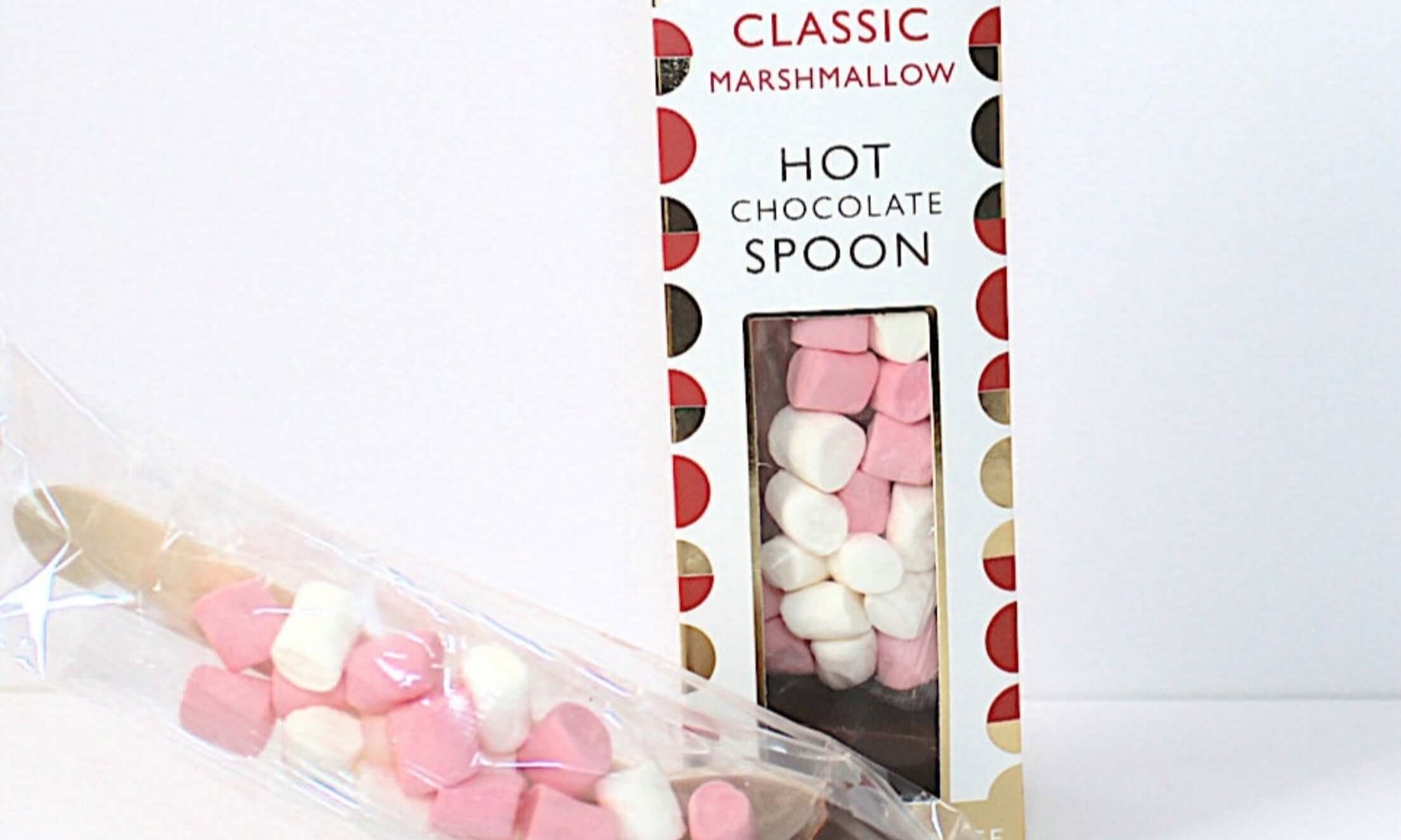 Hot chocolate spoon with marshmallows in a decorative packaging on a white background