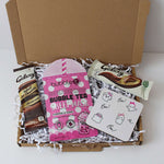 Box containing bubble tea- berries hydrating sheet mask and Galaxy chocolate bars on a white background.