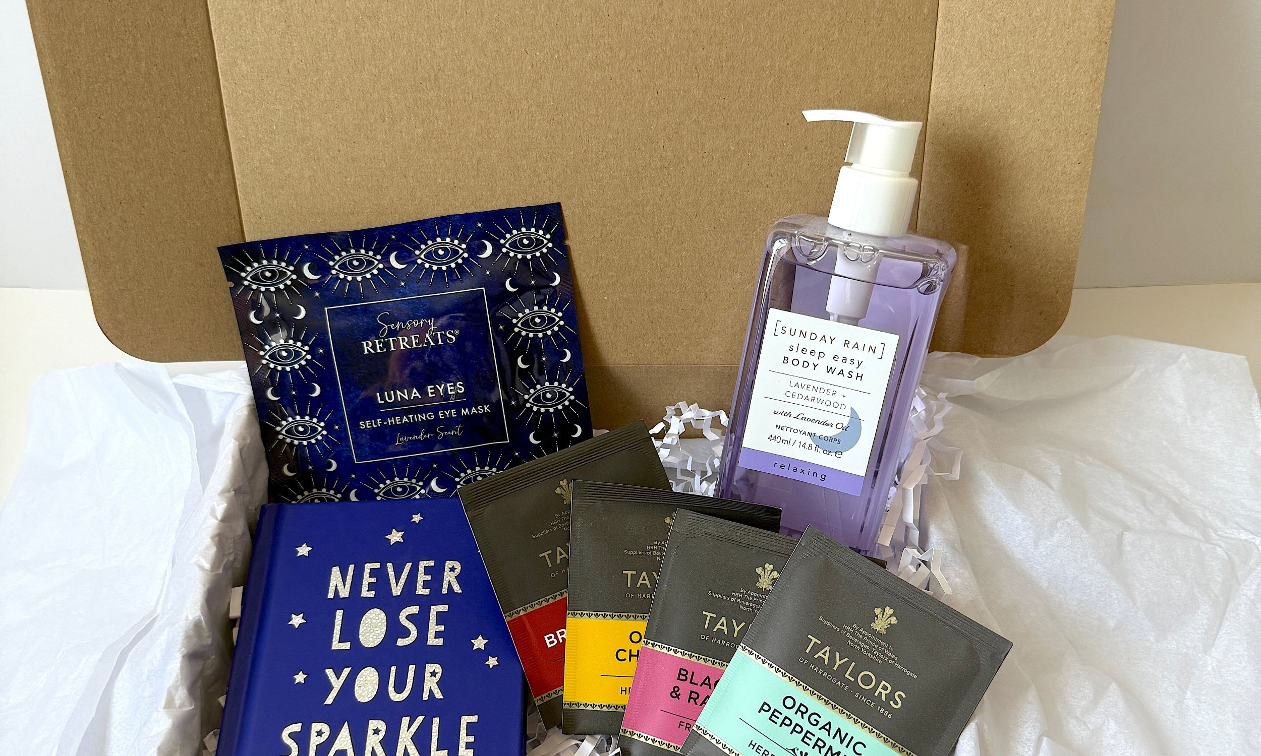 Never lose your sparkle gift set, 3 individually wrapped tea bags, never lose your sparkle book, sensory retreat heated eye mask, Sunday Rain lavender  ody wash.
