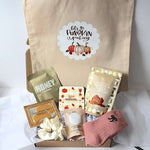 A beige canvas tote bag with a 'Let's Be Pumpkin Munching' graphic, displayed next to a curated gift box filled with fall-themed items including a pink knit sock, cookie and fudge clusters, coaster, under eye patches, aromatherapy bath salts, hair scrunchie  and lapcos honey sheet mask