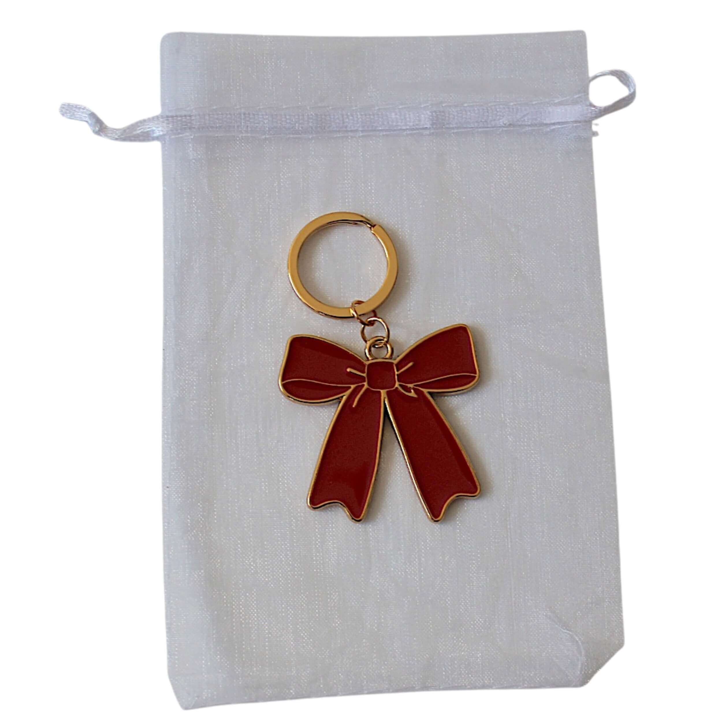 Red bow metal keyring on white bag 