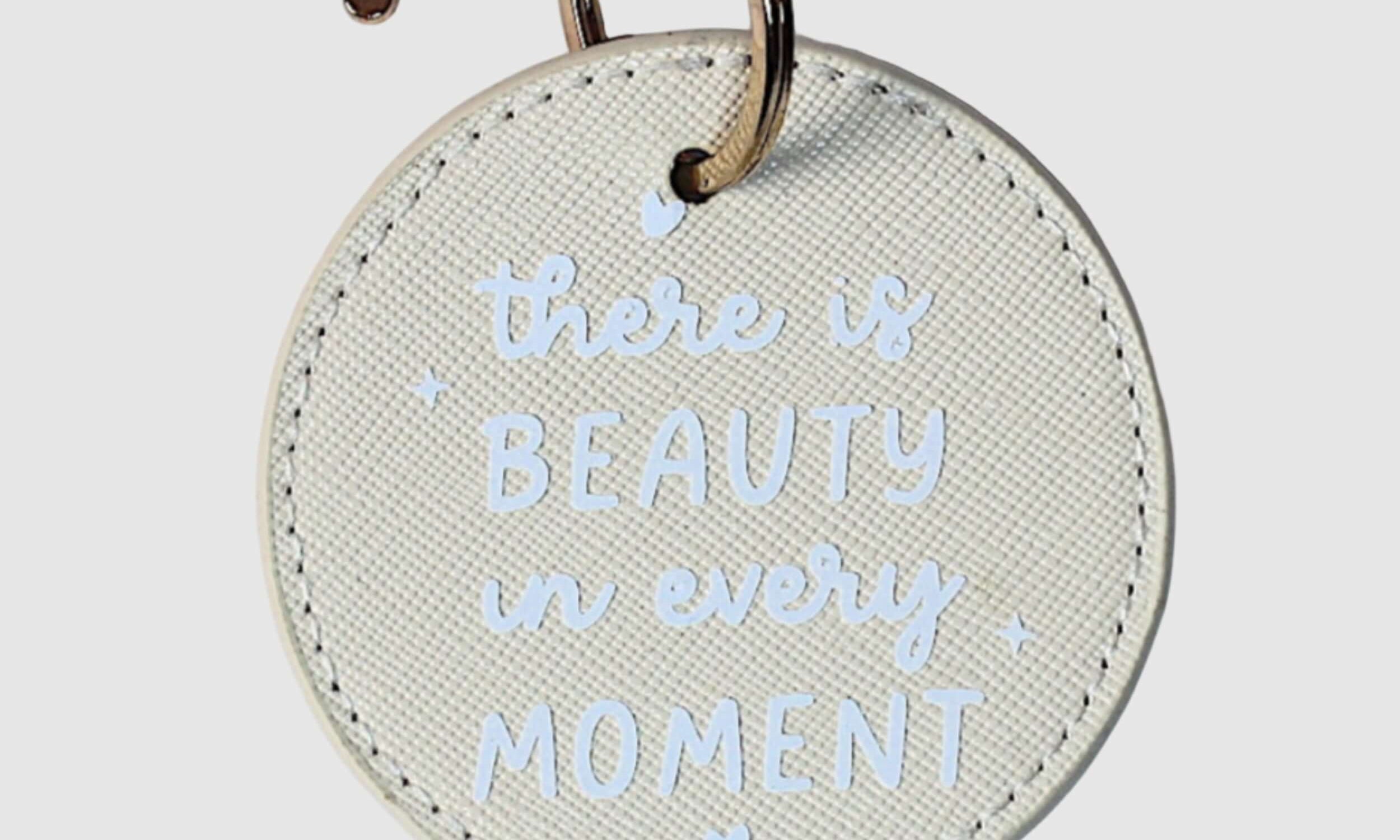 Round keychain with 'there is beauty in every moment' 
