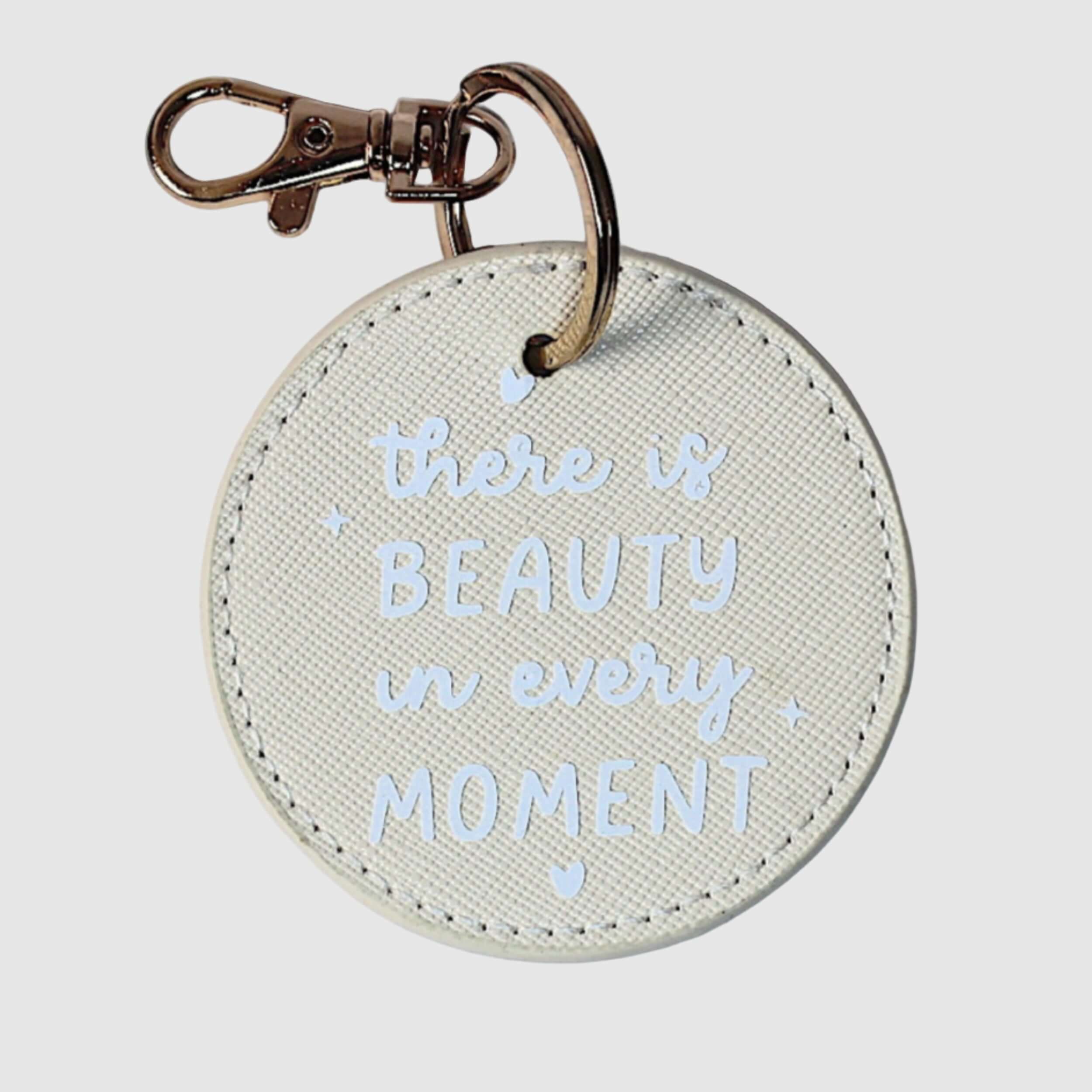 Round keychain with 'there is beauty in every moment' 
