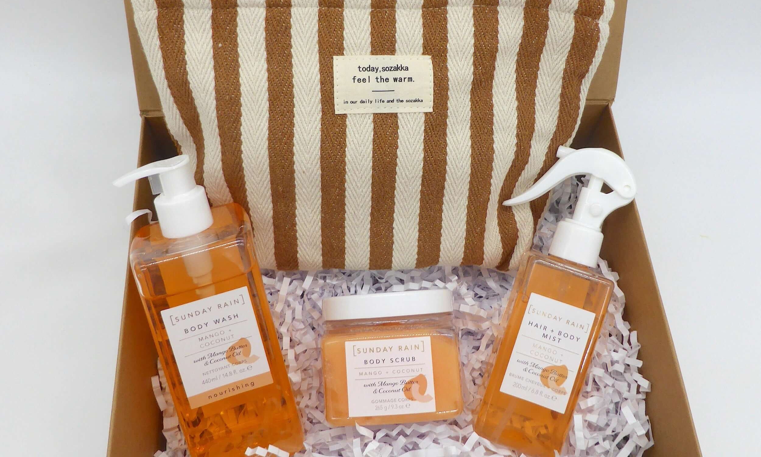 Summer gifting pamper gift box with mango and coconut body care products, featuring a stylish striped pouch.
