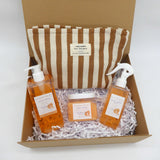 Summer gifting pamper gift box with mango and coconut body care products, featuring a stylish striped pouch.