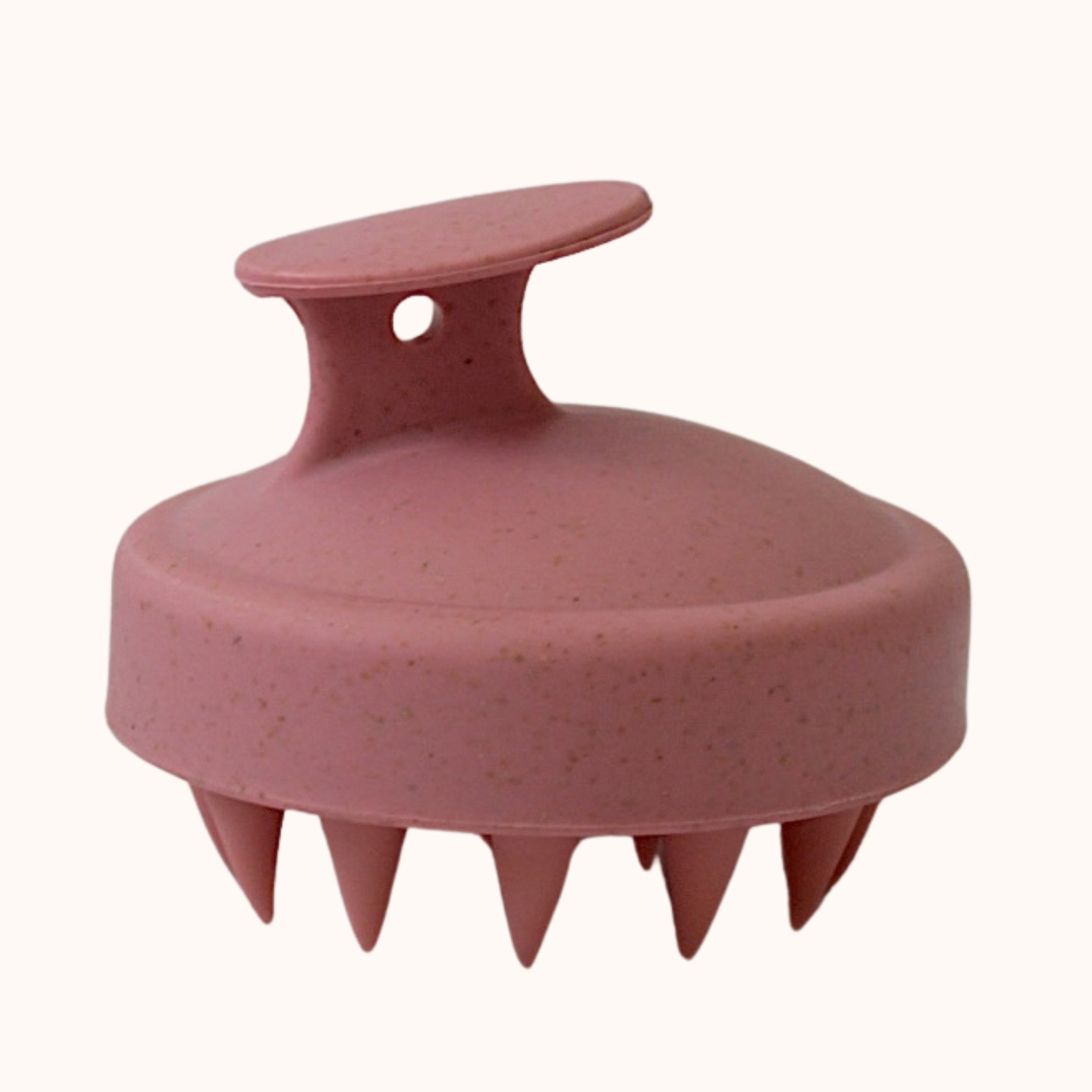 A pink textured hair massager brush with a loop handle, shown against a plain off-white background.